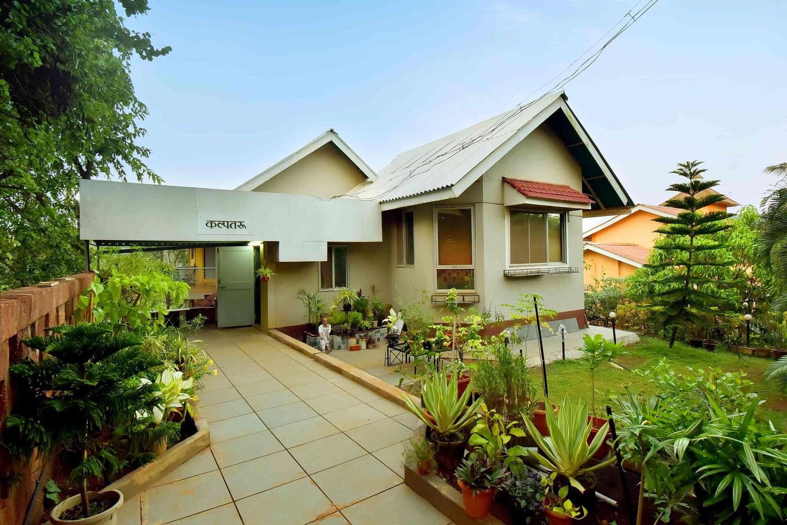 Kalpataru Holiday Home bungalow with lush garden and paved pathway, Dapoli