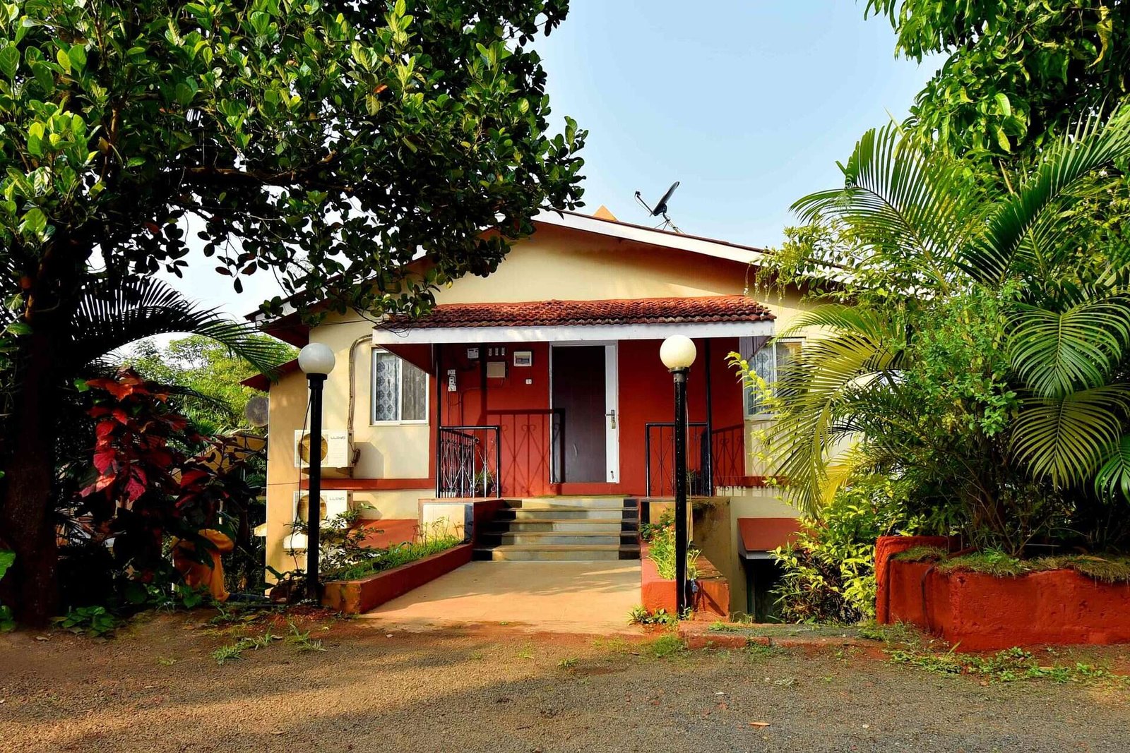 Deluxe Villa Yashwant in Dapoli, terracotta-roofed entrance surrounded by lush garden